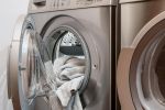 Geöffnete Waschmaschine, Wäsche quillt heraus
